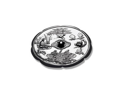 上海匡时2025年秋季拍卖会 中国历代钱币 铜镜专场 - 真子飞霜镜 八出葵花形，镜背下方一泓清池，水波粼粼，中央向上延伸出一株荷叶，莲茎笔直，莲叶舒展，其上趴伏一只玄龟，呈「龟伏莲叶」以意景，寓千岁长寿。玄龟腹部穿孔作钮，构思巧妙。左侧高士端坐抚琴，身前几案陈列，上置文房雅器，身后修竹坚韧；右侧鸾凤闻琴音而独舞，意境高雅脱俗，上方仙鹤翩飞，远处云气之间仙山隐约，构成一幅清幽通明的高士隐逸图。