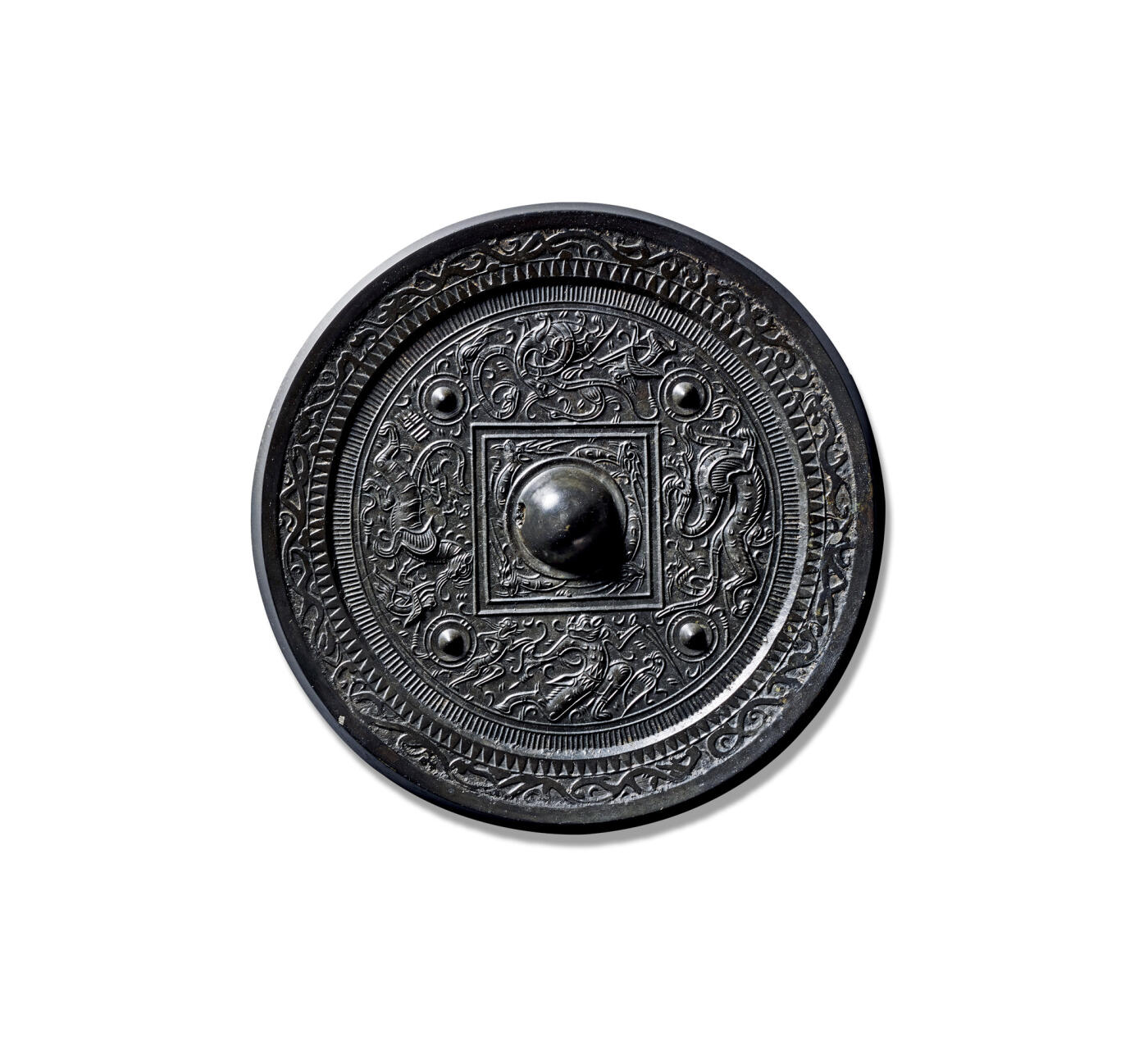 上海匡时2025年秋季拍卖会 中国历代钱币 铜镜专场 四乳羽人神兽镜 圆形，圆钮，圆钮座，钮座外方形凹面界格内环饰四只神鹿纹。四枚圆座乳钉将主纹饰分为四区，其间饰四神纹配饰羽人禽鸟纹，分别组合分别为青龙尾部饰一羽人、手执利剑的神兽配饰羽人和朱雀纹、白虎身旁配饰两个羽人纹，旁饰“白虎”两字铭文、玄武配饰两只朱雀纹和一单腿跪拜的羽人纹。四神纹饰刻画精美，羽毛、龙鳞的刻画精细入微，动物造型极为生动传神。镜缘饰一周锯齿纹和一周变形环绕的四神纹。镜黑漆古，状态