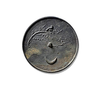 上海匡时2025年秋季拍卖会 中国历代钱币 铜镜专场 - 月影寒梅纹镜 圆形，小圆钮。镜缘饰回纹为框，框内一支寒梅横斜而出，几朵含苞，几朵绽放。一旁新月倒映水中，波平如镜，气象清冷高洁。有诗云：“天恐梅花不耐寒，遣将孤月问平安。未须一夜都开尽，留取前前后后看。”此镜意境高远，执于掌中，如坐书房，静观窗外景致。此镜纹饰留有大量空白，极具中国美学特征。正如书画中的留白艺术，为求整体协调精美，有意保留相应虚空，予人以想象空间。其强调主观意兴与心绪，充分传达“人