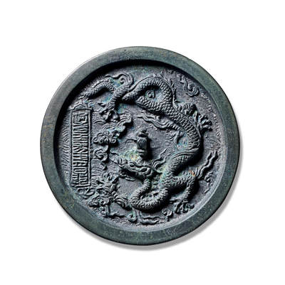 上海匡时2025年秋季拍卖会 中国历代钱币 铜镜专场 - 洪武二十二年单龙镜 圆形，山形钮，镜背施浮雕之技装饰一条修长苍健、气势磅礴的龙纹，背脊明显，鳞甲清晰，四肢舒展作凌空之态，地章满饰海水纹。龙呈双角之姿，瞠目隆眉，且为五爪之象，等级极高，左侧莲花之间置铭文方格，上书篆体“洪武二十二年正月日造”，为洪武龙纹的标准器，包浆古朴熟美，完美品相。