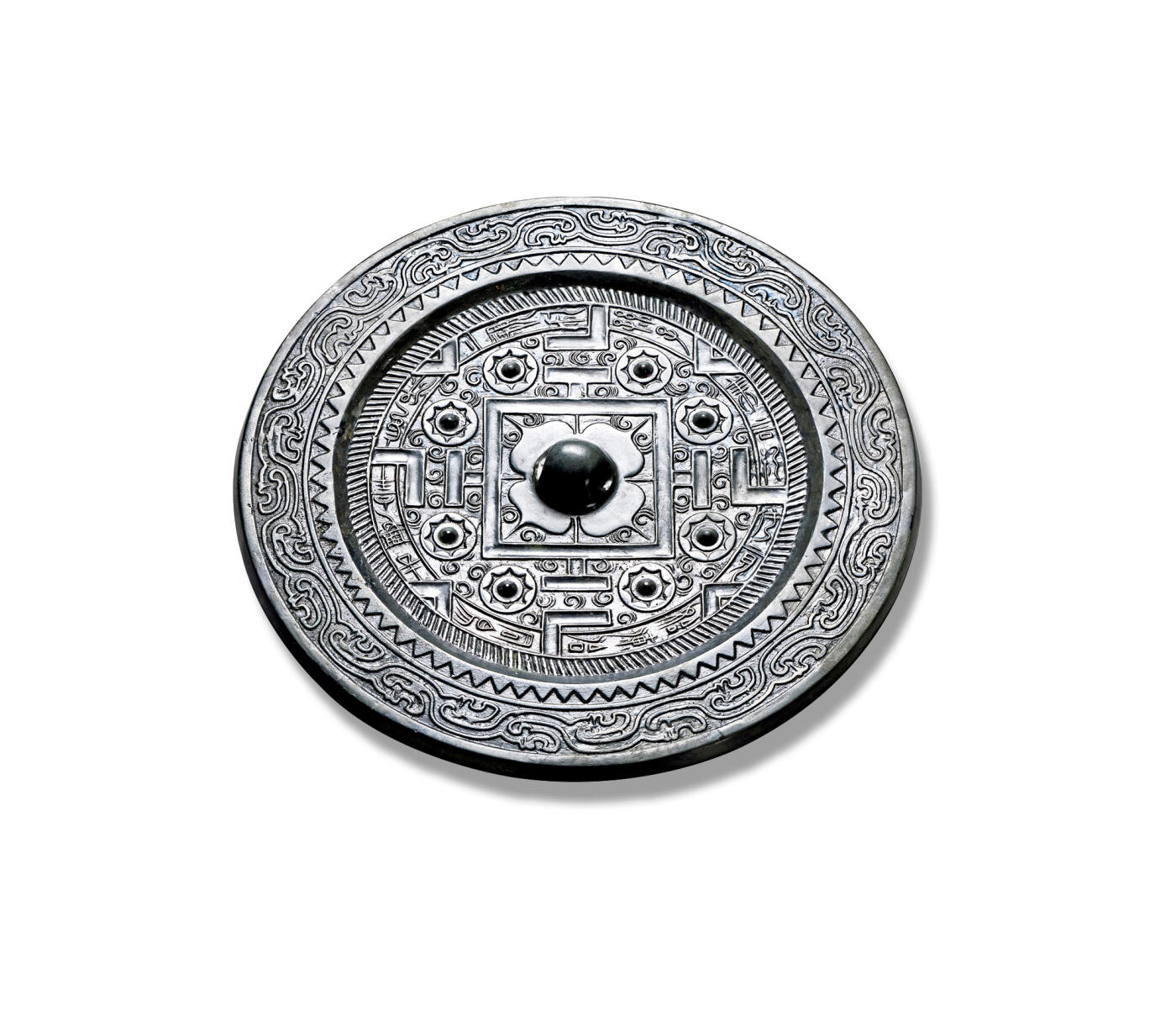 上海匡时2025年秋季拍卖会 中国历代钱币 铜镜专场 “桼言之纪”神兽规矩镜 圆形，圆钮，柿蒂纹钮座。钮外双线凹面方格内，四角各饰两组半圆卷叶纹。四“T”纹两侧配以圆钮座八乳钉，并与博局纹共同将主区分为四方八区，其间以卷叶纹间隔，“V”纹两两相对，中夹八区铭文：“桼言之纪从竟始，湅怡铜锡去其宰，长保二亲利孙子。”外围饰一周栉齿纹。镜缘宽厚平整，饰一周锯齿纹与一周双线水波纹。此镜通体黑漆古，纹饰与字口皆清晰规整。惜裂修。