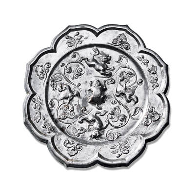 上海匡时2025年秋季拍卖会 中国历代钱币 铜镜专场 - 镂空腿双鸳鸯双狮镜 八出菱花形，伏兽钮。主题纹饰分为四区，两对展翅鸳鸯与两头咆哮跳跃的狮子相间排列，其间饰以四组缠枝花卉。鸳鸯羽翼舒展，姿态飘逸；瑞兽形体丰硕，动作夸张，张口怒吼，神态生动。缠枝花卉婉转流畅，衬托出富丽华贵之气。镜缘饰以祥云与花枝纹，清新婉约，自然优美。此镜铸造工艺精湛，风格富丽华美。镜体泛银白光，熠熠生辉，整体画面生机盎然，自由活泼中见矫健挺拔之美，彰显出盛世时期丰腴华丽的审美趣