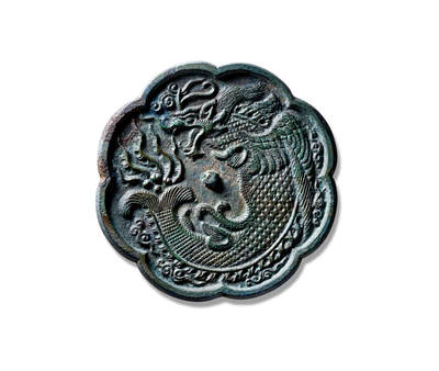 上海匡时2025年秋季拍卖会 中国历代钱币 铜镜专场 - 鱼化龙镜 八出葵花形，圆钮。镜背以高浮雕工艺饰鱼化龙纹，身躯丰硕，鳞甲历历，瞠目张口，威仪自生。肩部双翼舒展，羽片层迭；尾部环以火焰纹，正呈蜕变飞升之势。整体构图饱满，刻画精细入微，品相完好。
