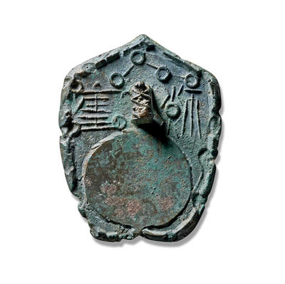 上海匡时2025年秋季拍卖会 中国历代钱币 铜镜专场 - 盾形北斗铭文阳隧镜 镜盾形，兽钮，钮上由圆圈及线条相连的北斗七星图案，两字符文位列镜钮左右，钮下为一外凸内凹圆形阳隧，整体造型古朴独特，体现了古人对道教的崇拜，在道家文化中，北斗七星被尊为“七元解厄星君”，寓意消灾解厄、主宰人命、延寿增福，阳隧兼具日常取火与祭祀用途。