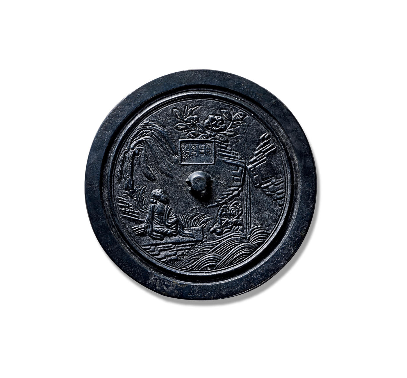 上海匡时2025年秋季拍卖会 中国历代钱币 铜镜专场 仙人观瀑人物故事镜 圆形，扁平圆钮，无钮座。近缘处有一周凸弦纹。镜背纹饰左上方饰芭蕉树一株，树下一位高士头戴峨冠、身着博带，倚坐左侧，姿态闲适；右侧层峦迭嶂，瀑布三迭飞泻，注入下方潭中。钮上方有阴文“河中府马家白铜镜”八字铭文，其上方更饰浮云飞鸟。此镜胎体较唐镜轻薄，镜钮亦较唐镜扁平，但未如金代铜镜般作削平处理。瀑布以线刻手法表现，为宋代铜镜所常见。整体纹饰清秀古雅，突出体现了宋代人物故事镜常配山