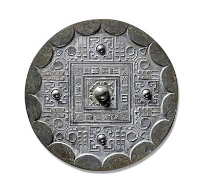 上海匡时2025年秋季拍卖会 中国历代钱币 铜镜专场 - “长贵富”草叶纹镜 圆形，圆钮，柿蒂纹钮座。钮座外有两个凹面方格构成的方形铭文框，框内四角饰多重菱形纹，四边铭文内容顺时针旋读：“长贵富，乐毋事，日有憙，得所喜，常宜酒食。”字形端庄典雅，结体方正谨严，纹饰区域四乳格局，于文字方界格四方对称装饰。方框每边外侧中间各有一四瓣座乳钉，形成四大花朵；花朵两侧各有一个三迭式草叶纹，叶内有叶脉状的直线纹；方框四角各向外伸出一个双叶瓣夹一花苞的花叶纹。镜外缘之