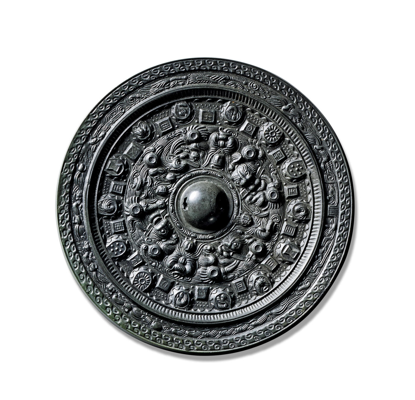 上海匡时2025年秋季拍卖会 中国历代钱币 铜镜专场 半圆方枚神人神兽镜 圆形，圆钮，圆钮座。镜缘内有一周凸棱，凸棱的斜面有一周锯齿纹。主纹饰内八个环状乳绕钮一周，四只嘴里衔矩的瑞兽均布，将纹饰分为四区，夹饰数组神态繁复的神人，纹饰区外有十四个半圆和十四个方枚间隔均布排列一周，每个半圆的立面均有锯齿纹，平面有瑞兽纹、太阳纹、几何纹等，每个方枚有一字铭文。在半圆与方枚之间的地章，布满了珍珠式的小点，镜缘装饰一周仙人出行图及卷云纹。整镜布局华丽严谨，铜质