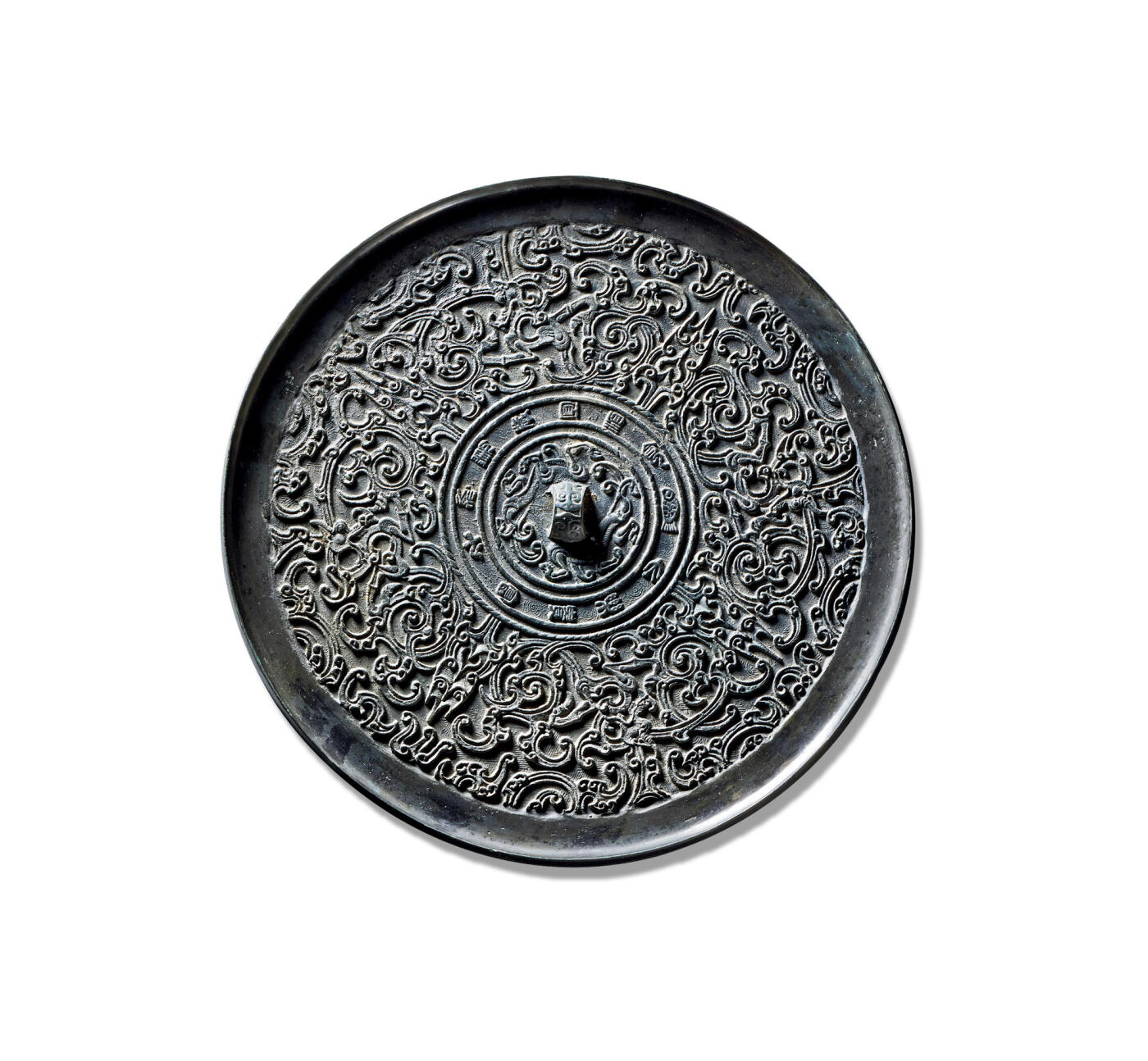 上海匡时2025年秋季拍卖会 中国历代钱币 铜镜专场 “大乐富贵”蟠螭纹镜 此镜为少见的蟠螭纹题材，圆形，铸工精湛，制作精美，版工力度极佳，属头版头模之作。其造型承袭该时期铜镜风格，设三弦兽钮，颇具创意，可见在继承中亦见创新。三弦钮的装饰意涵取自兽身，后渐发展为完整的伏兽钮。镜缘外饰一周铭文圈带，内饰“大乐贵富，千秋万岁，宜酒食”，铭文间以鱼纹相隔。主区由四株双叶花叶纹划分为四部分，内饰变形蟠螭纹，刻画精细入微。螭首怒目圆睁，张口露齿，躯体盘绕回旋，