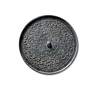 上海匡时2025年秋季拍卖会 中国历代钱币 铜镜专场 - “大乐富贵”蟠螭纹镜 此镜为少见的蟠螭纹题材，圆形，铸工精湛，制作精美，版工力度极佳，属头版头模之作。其造型承袭该时期铜镜风格，设三弦兽钮，颇具创意，可见在继承中亦见创新。三弦钮的装饰意涵取自兽身，后渐发展为完整的伏兽钮。镜缘外饰一周铭文圈带，内饰“大乐贵富，千秋万岁，宜酒食”，铭文间以鱼纹相隔。主区由四株双叶花叶纹划分为四部分，内饰变形蟠螭纹，刻画精细入微。螭首怒目圆睁，张口露齿，躯体盘绕回旋，