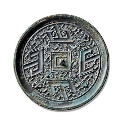 上海匡时2025年秋季拍卖会 中国历代钱币 铜镜专场 - 四山镜 圆形，三弦钮，方钮座。外围饰方形凹面环带以象征大地，与象征苍天的圆形镜体相呼应，体现了古人“天圆地方”的宇宙观念。方框四角各伸出一组花叶纹。主题纹饰为四组“山”字纹与羽状地纹相结合的复合纹样，主纹方正庄重，地纹细密秀丽，两者层次分明，布局严谨。四组“山”字纹呈左旋排列，其中间竖笔顶端抵于镜缘。此镜保存完好，状态极佳。