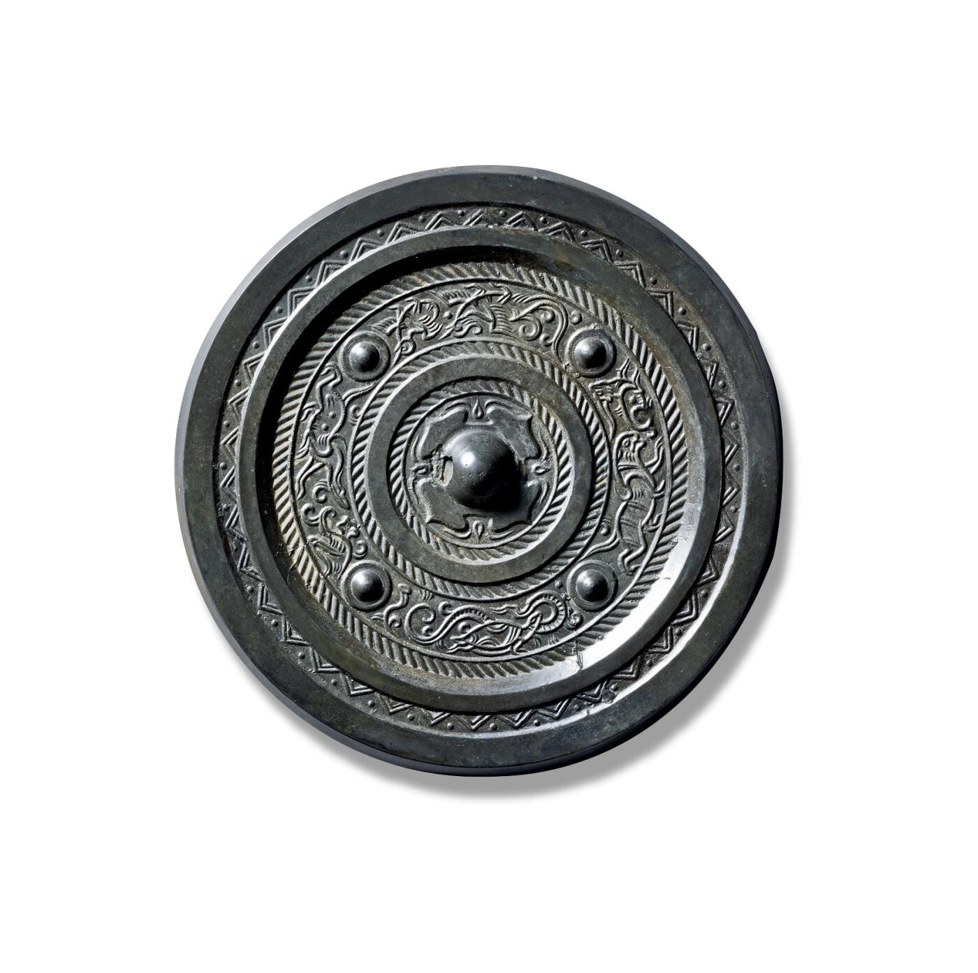 上海匡时2025年秋季拍卖会 中国历代钱币 铜镜专场 四乳四神镜 圆形，圆钮，柿蒂纹钮座。钮座外以四枚乳钉将镜背主题纹饰分隔四区，分饰青龙对羽人、白虎对瑞兽、朱雀对凤鸟、玄武对灵草，四神情态诙谐，刻画细致入微，表情生动。