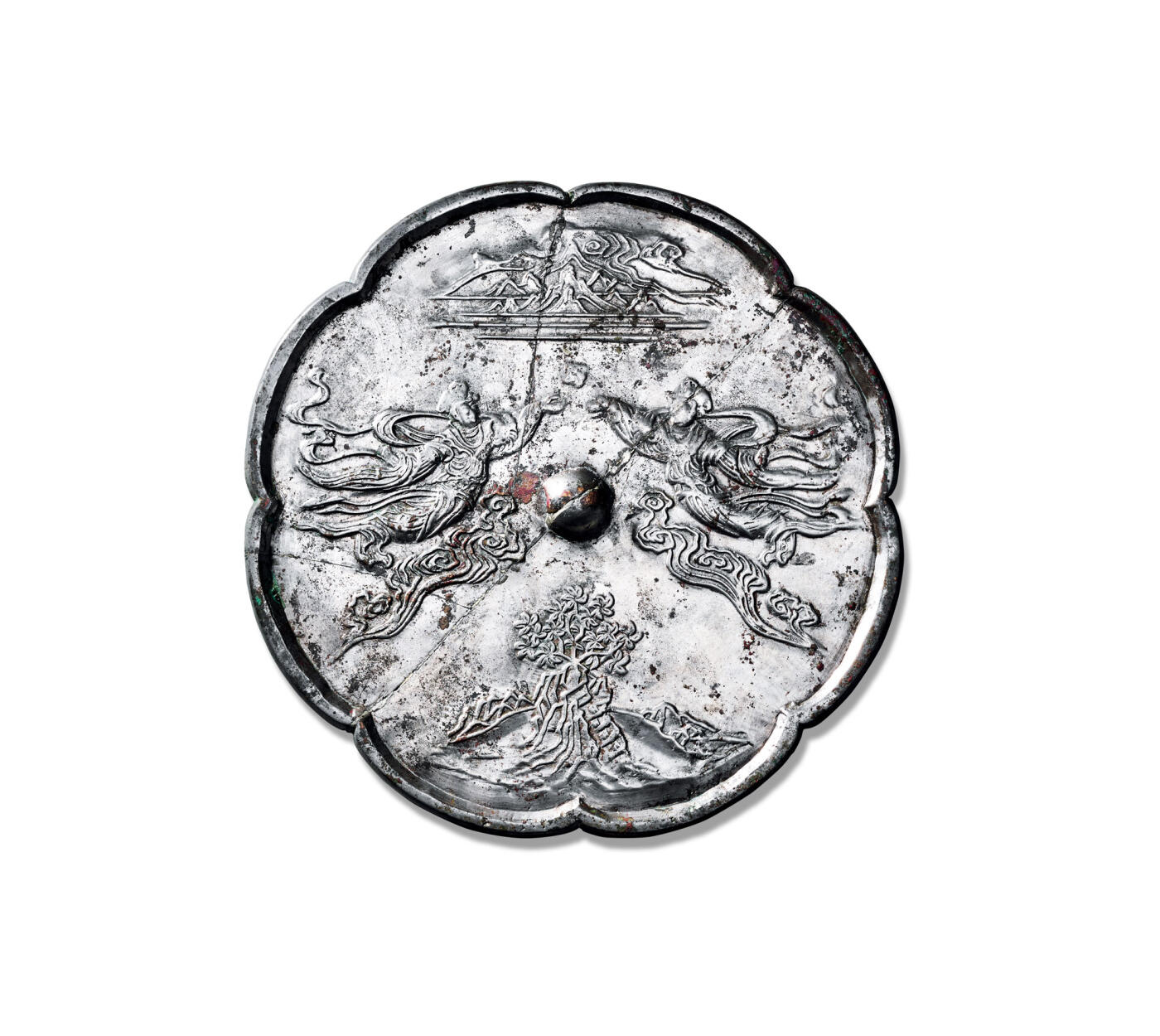 上海匡时2025年秋季拍卖会 中国历代钱币 铜镜专场 仙人飞天神仙人物镜 八瓣葵花形，圆钮。钮座两边各饰有一大型神仙人物脚踏祥云似凌空飞翔姿态，上方饰仙山，巍峨高耸，苍茫云海间。下方饰仙山山峰的一颗菩提树，树影婆娑，静心出能悟道深。明镜台前无俗物，菩提树下悟禅音，心境自然清。绿意盎然间，智慧与宁静共生，心如止水尘世烦恼尽抛，方可得道飞升，人物通过衣带飘动等细节呈现动态视觉效果，体现佛教飞升思想。飞天铜镜是佛教艺术本土化的产物，兼具实用性与艺术性，反映