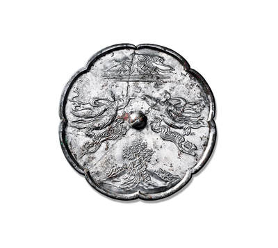 上海匡时2025年秋季拍卖会 中国历代钱币 铜镜专场 - 仙人飞天神仙人物镜 八瓣葵花形，圆钮。钮座两边各饰有一大型神仙人物脚踏祥云似凌空飞翔姿态，上方饰仙山，巍峨高耸，苍茫云海间。下方饰仙山山峰的一颗菩提树，树影婆娑，静心出能悟道深。明镜台前无俗物，菩提树下悟禅音，心境自然清。绿意盎然间，智慧与宁静共生，心如止水尘世烦恼尽抛，方可得道飞升，人物通过衣带飘动等细节呈现动态视觉效果，体现佛教飞升思想。飞天铜镜是佛教艺术本土化的产物，兼具实用性与艺术性，反映