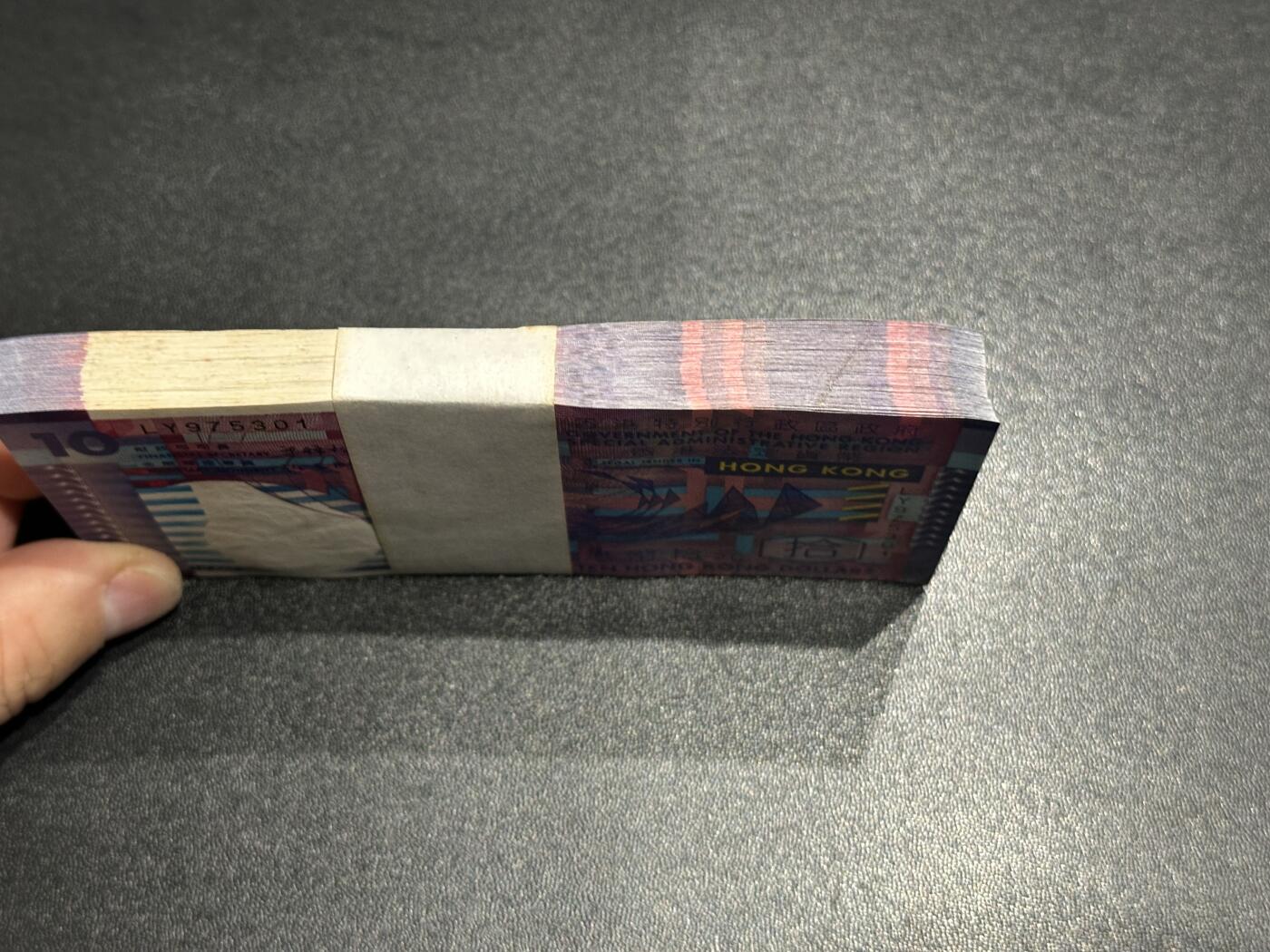 《外钞收藏家》第五百九十二期（精选场）（本平台长期征集拍品、欢迎藏友们联系合作） 香港2002年初版政府发行10元一刀百连（含豹子号333）	UNC 轻微发黄和黄点