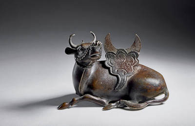 上海匡时2025年秋季拍卖会 中国历代钱币 铜镜专场 - 犀牛望月镜架 铜质，镜架整体呈犀牛望月状，鎏金犀牛作自然回首跪卧状，犀牛背上祥云凸起，托起一个弯月形的用来搁靠铜镜的部件，祥云和弯月之间有空槽，摆放铜镜时，只要将铜镜插入空槽之中，铜镜便稳稳地靠在弯月形的部件上。此镜架铸造精良，造型生动可爱，保存状态完好。