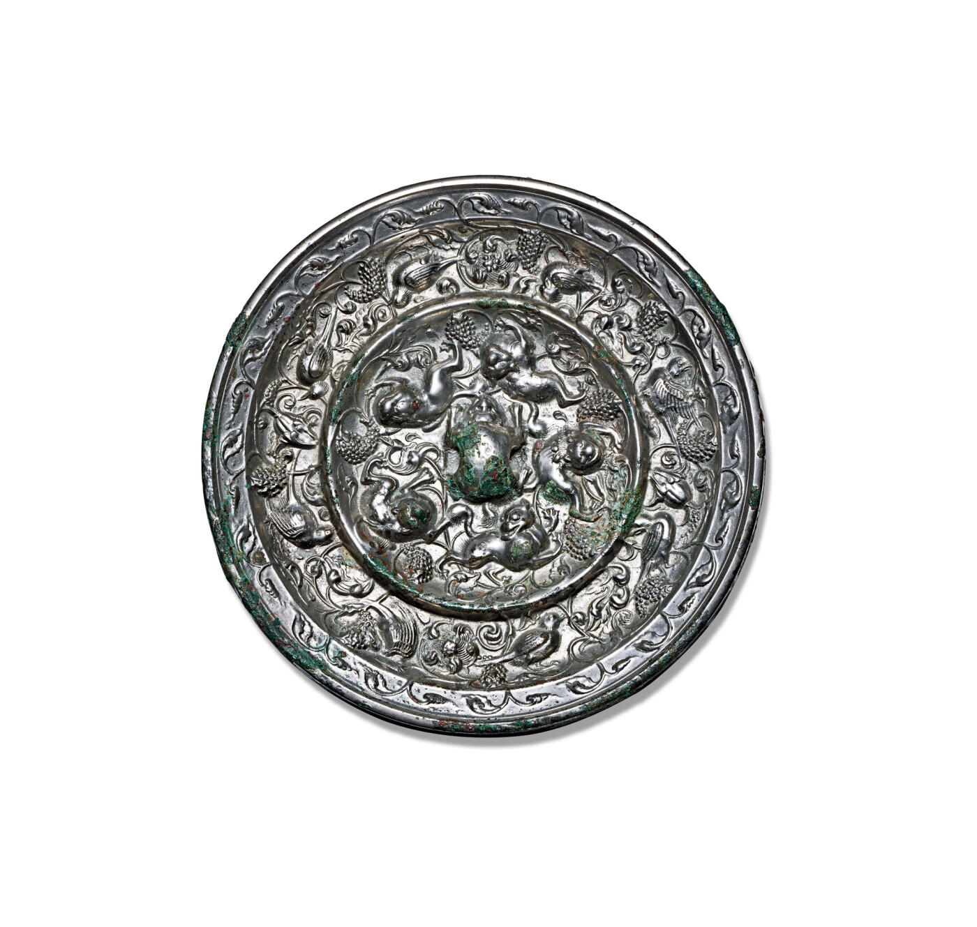 上海匡时2025年秋季拍卖会 中国历代钱币 铜镜专场 海兽葡萄镜 圆形，伏兽纽。一圈高耸的轮脊把镜背纹饰分成内外二区，内区五瑞兽环绕镜钮，造型不一，有的回首顾盼，有的昂首阔步，形态各不相同，动态丰富，造型浑厚，生趣自然。其间饰葡萄纹及枝叶纹饰。枝叶纹相互穿插缠绕，形式优美。外区葡萄藤蔓、宝相花与禽鸟相间分布，布局精细。镜体白光，光气匀亮，工艺细腻，保存完整。