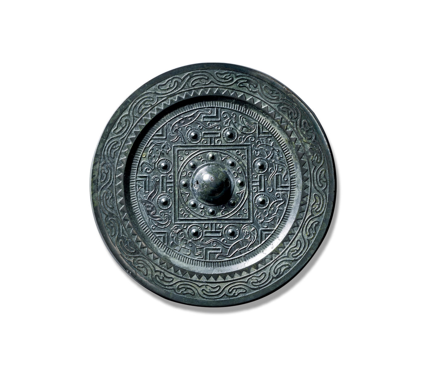 上海匡时2025年秋季拍卖会 中国历代钱币 铜镜专场 四灵神兽规矩镜 圆形，圆钮，圆钮座，钮座外有八乳钉相间芝草纹。双线凹面方格外四“T”纹两侧有八乳钉与规矩纹将主纹饰分为四方八区内装饰四灵瑞兽两两相对，线条流畅。镜缘一周锯齿纹与流云纹。此镜保存完好，状态佳，铜质精良，镜体干净，黑漆古且光质佳。