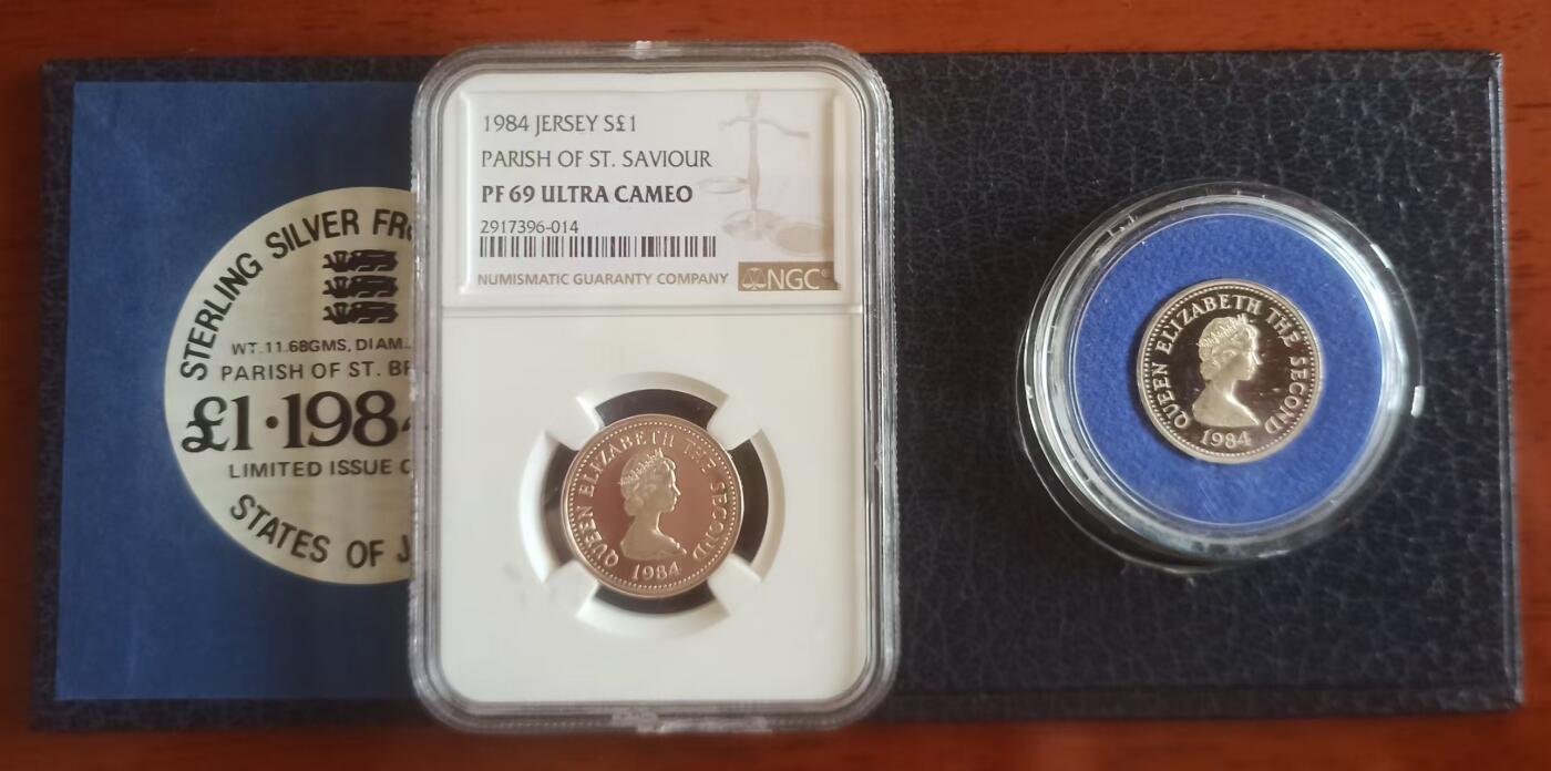 ❤️【币观天下】❤️ 第334期钱币拍卖- 2025.12.12周五晚上6点半场-长期征集拍品 泽西1984年教区一镑精制银币一对 发行量2500枚 圣布莱德和圣萨维尔教区 原盒证和NGC69一样一枚