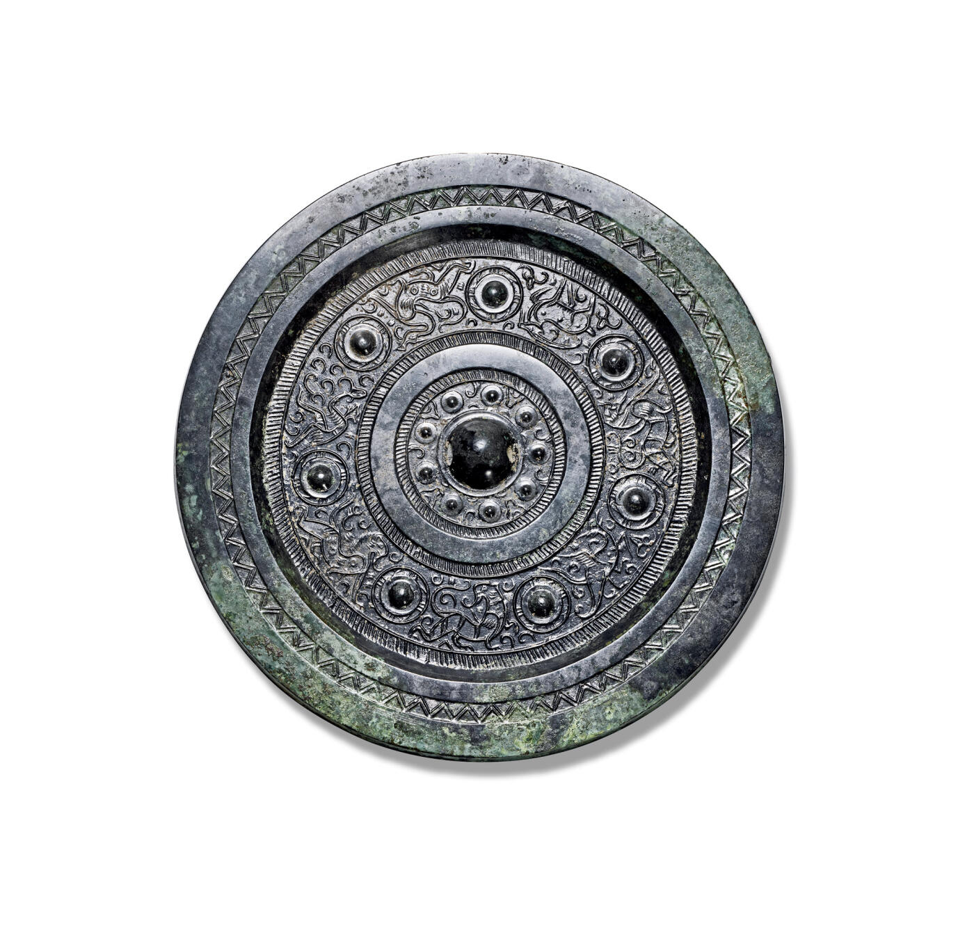 上海匡时2025年秋季拍卖会 中国历代钱币 铜镜专场 七乳神兽镜 圆形、圆钮、圆钮座。钮座外环饰九枚乳钉相间花苞纹，其外双圈栉齿纹夹一圈素炫纹，主纹饰为七枚乳钉相间青龙、白虎、朱雀、山羊、瑞兽、羽人、神鸟等纹饰，主纹外装饰一周栉齿纹，宽厚镜缘上饰一周双线锯齿纹。保存完好、美品、原白光，收藏佳品。