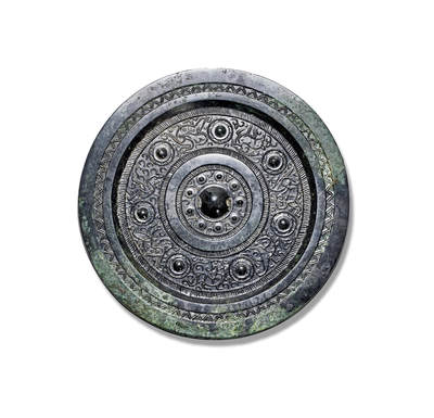 上海匡时2025年秋季拍卖会 中国历代钱币 铜镜专场 - 七乳神兽镜 圆形、圆钮、圆钮座。钮座外环饰九枚乳钉相间花苞纹，其外双圈栉齿纹夹一圈素炫纹，主纹饰为七枚乳钉相间青龙、白虎、朱雀、山羊、瑞兽、羽人、神鸟等纹饰，主纹外装饰一周栉齿纹，宽厚镜缘上饰一周双线锯齿纹。保存完好、美品、原白光，收藏佳品。