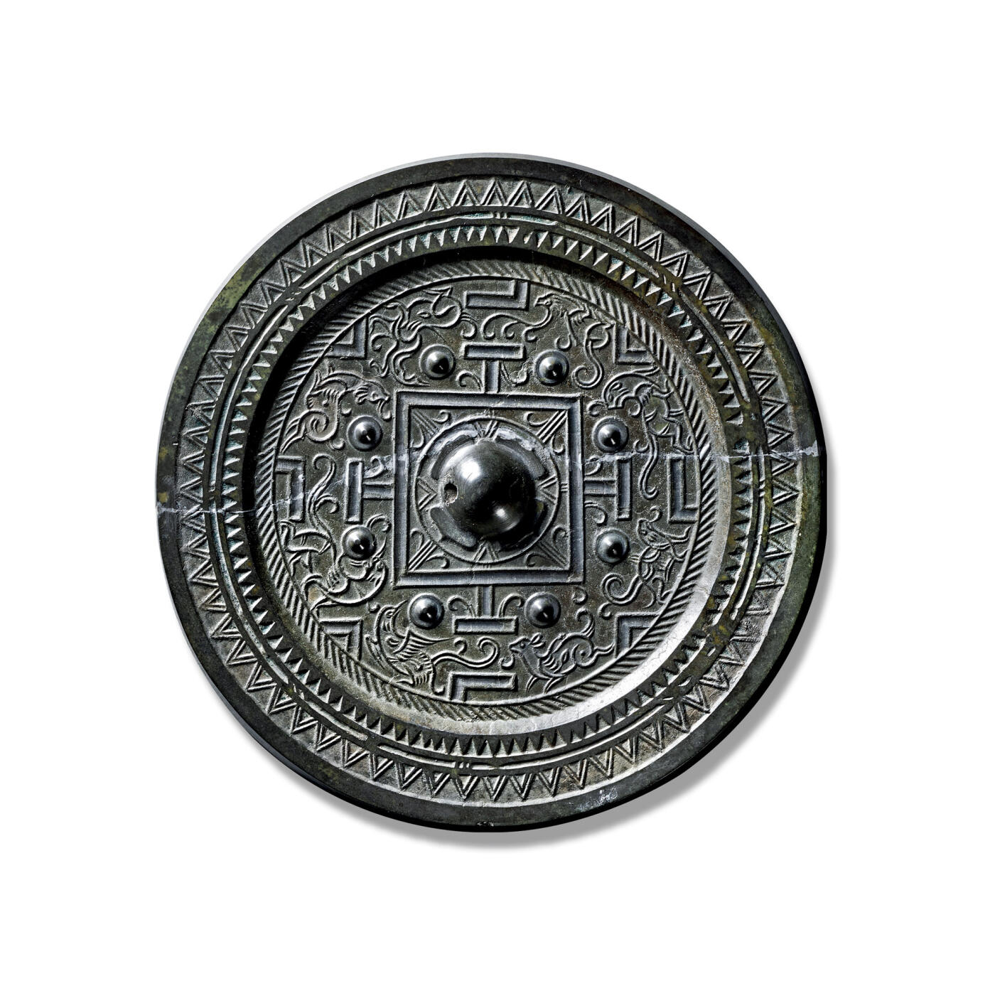 上海匡时2025年秋季拍卖会 中国历代钱币 铜镜专场 八乳神兽规矩镜 圆形，圆钮，柿蒂纹钮座。主题纹饰为凹面方框规矩纹及八乳钉，将镜背分为四区八方，分别饰一神兽一伴兽，空白处填满芝草纹，近缘处饰一圈栉齿纹。镜缘饰三角锯齿纹及双线波折纹。此镜纹饰线条流畅，动物形象生动，制作规整，惜裂修。