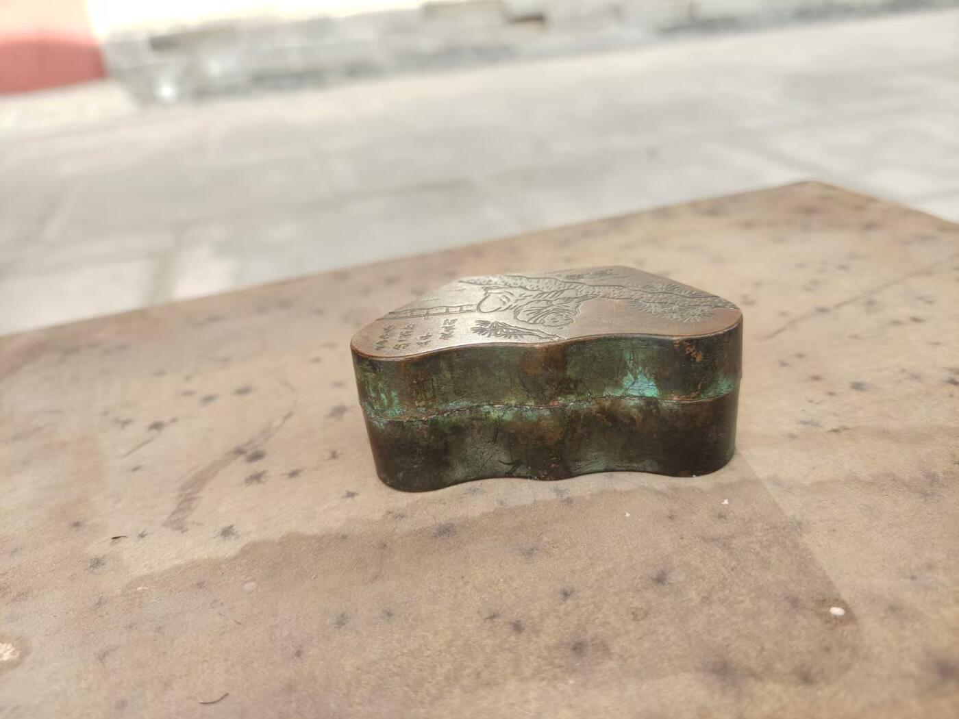 民国老铜墨盒一个，纯铜材质，雕松树人物，带诗文题记，底款“瑞珍”。元宝形，包浆自然老道，整体完整，盖子盖得紧，配件齐全，无漏裂。