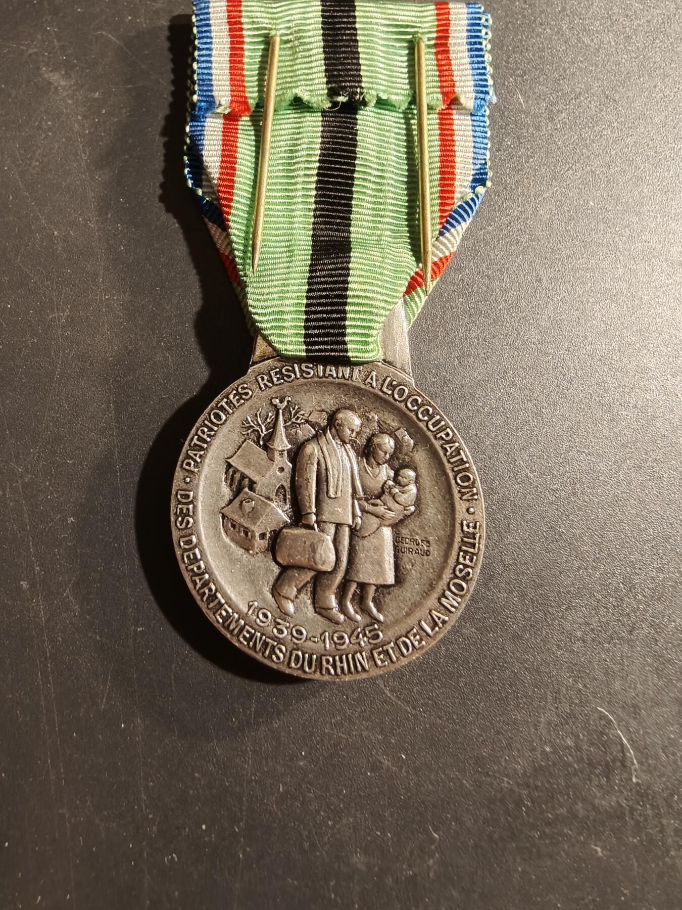 老王徽章第169期 法国二战流亡爱国者纪念章     原盒      该纪念章于1954年由法令设立，名为“1939-1945年流亡爱国者纪念章”，专门授予那些通常居住在阿尔萨斯-洛林/莱茵-摩泽尔省的法国公民，他们在纳粹占领期间被捕、驱逐出境并被关押在集中营，或被宣布为非法移民、流放或被迫迁往其他敌占区。
