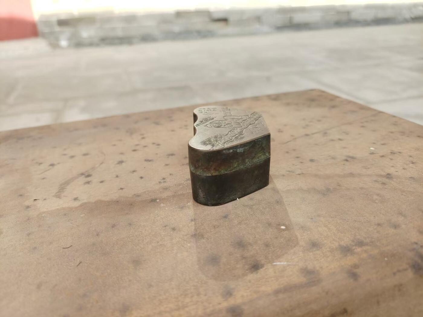 民国老铜墨盒一个，纯铜材质，雕松树人物，带诗文题记，底款“瑞珍”。元宝形，包浆自然老道，整体完整，盖子盖得紧，配件齐全，无漏裂。