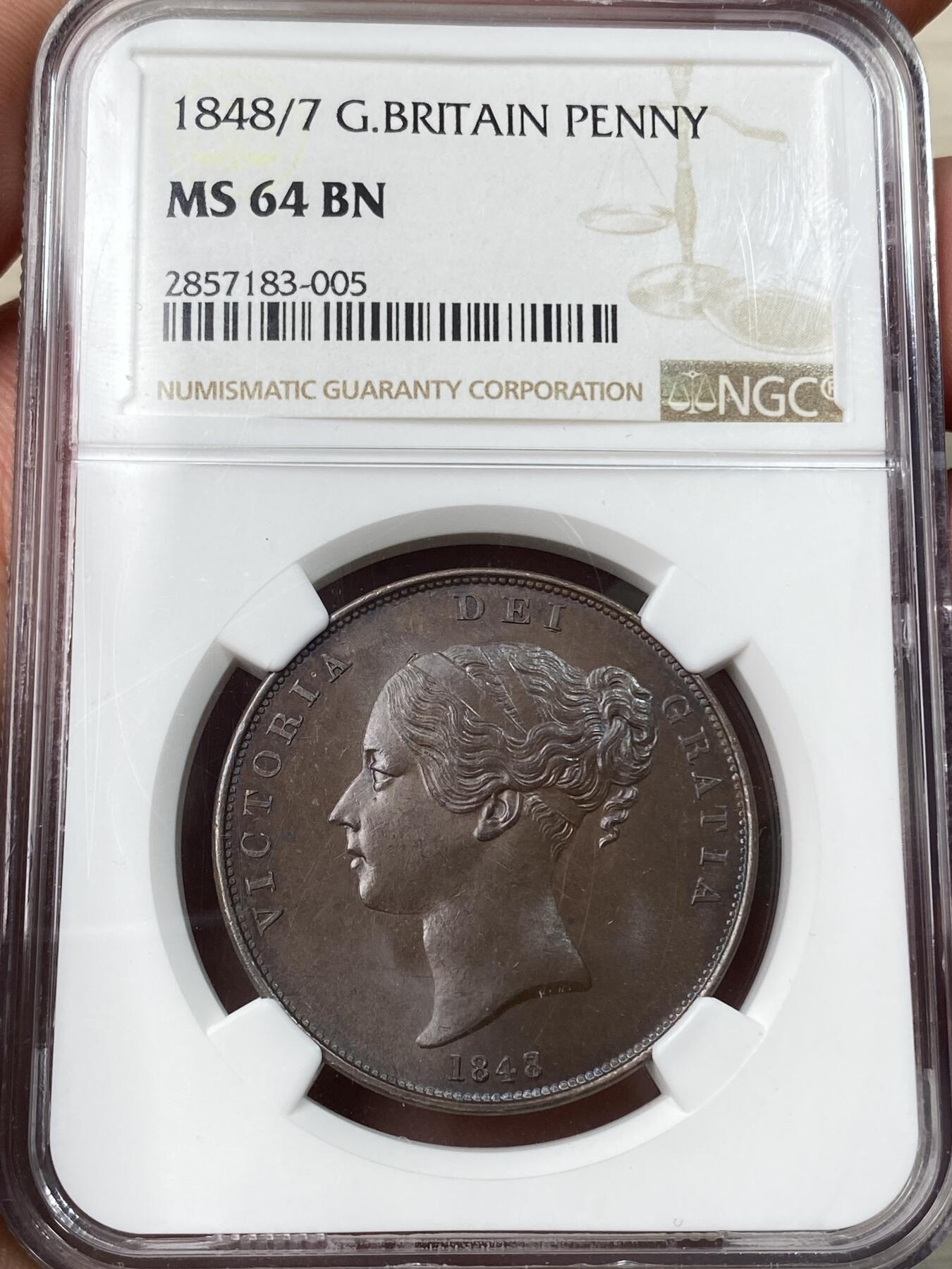 万国钱币拍卖第057期（万国冬季大拍） NGC MS64 1848/7年英国维多利亚便士，人见人爱的小维便士，早期用料很足，又大又厚，原铜色非常舒服。高分顶级状态，大颗巧克力 双面紫罗兰火焰彩，实物极美。稀有的骑字版，市面很难见到。63分克劳斯目录很久之前的参考价就是950美金，英系价格已经上了一个台阶。热门收藏潜力股，年轻可爱辫子头小维。