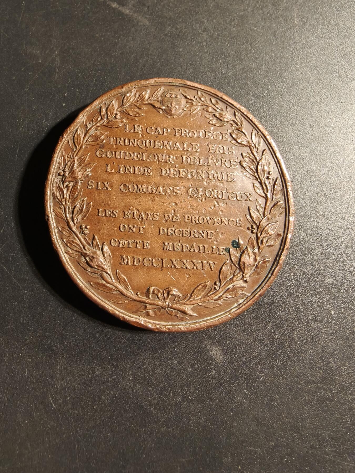 老王徽章第169期 法国1784年海军上将皮埃尔·安德烈·德·苏弗朗·德·圣特罗佩印度洋战胜英军大铜章    背面纪念了苏弗朗在印度洋战役中的关键成就，包括在开普敦抵御英军入侵、攻占亭可马里以及解放古德洛尔等，这些胜利巩固了法国在印度的地位      直径50mm.   重量55.3g 