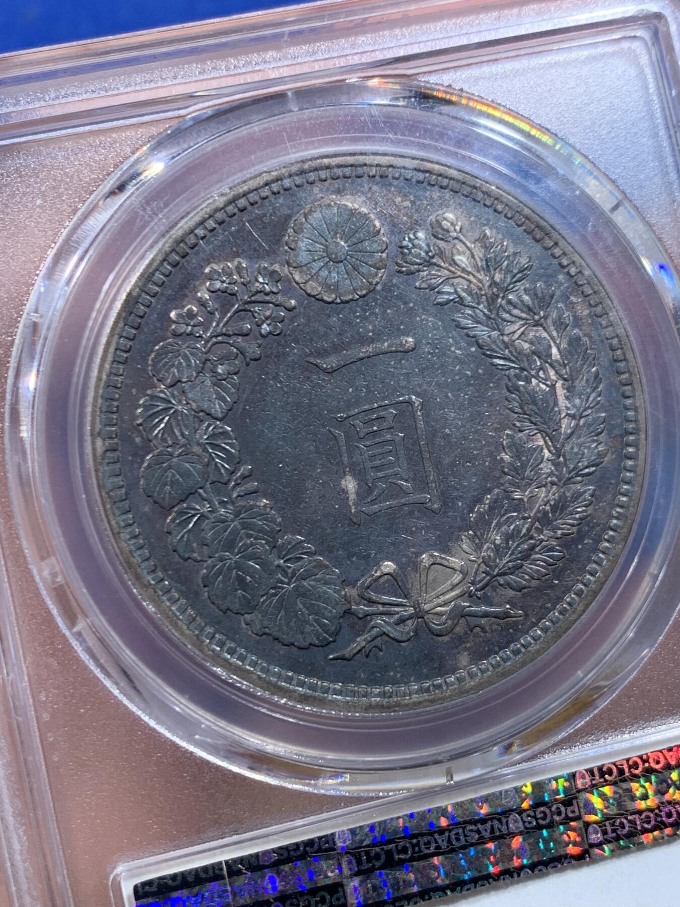 《竞宝斋》第447场 周日，周一，2场连拍 （全场包邮） PCGS AU55 日本明治十六年大型龙洋一元银币，正面金彩，背面黑彩，早期年份，状态不错。