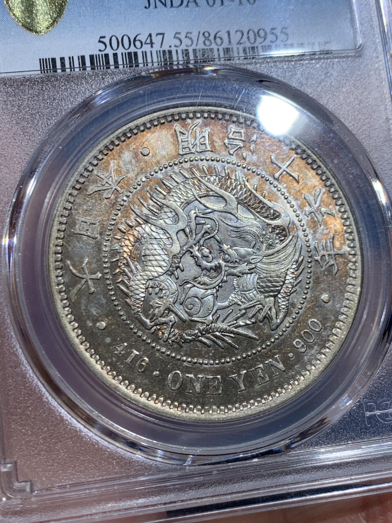 《竞宝斋》第447场 周日，周一，2场连拍 （全场包邮） PCGS AU55 日本明治十六年大型龙洋一元银币，正面金彩，背面黑彩，早期年份，状态不错。