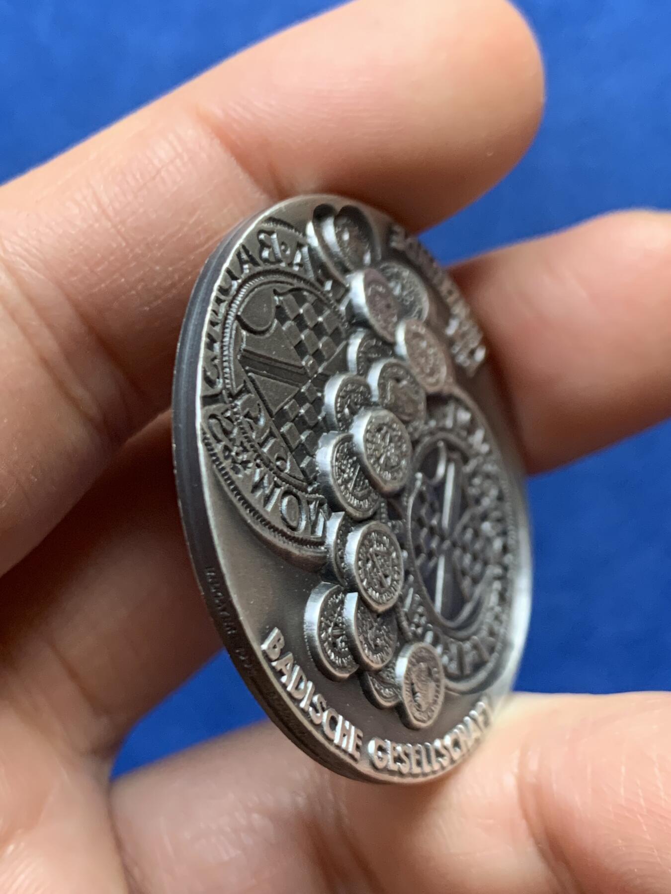 《竞宝斋》第447场 周日，周一，2场连拍 （全场包邮） 德国巴登地区货币历史纪念纯银银章 该章上环绕着多枚小型仿古钱币浮雕，这些是历史上巴登地区流通的货币样式，展示了该地区货币发展的多样性与历史脉络。35.3克，40.2mm，带边铭，双面高浮雕。