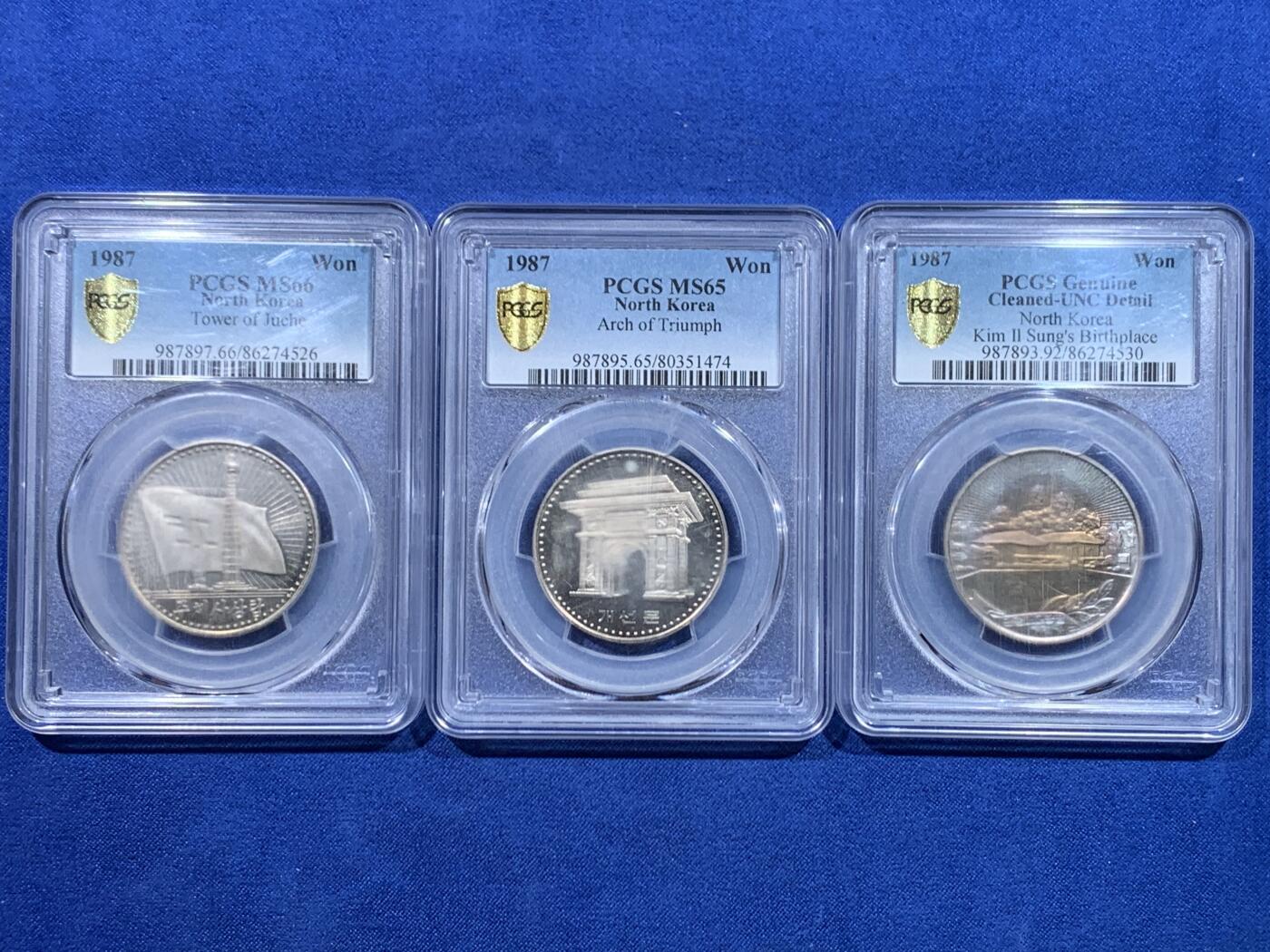 《竞宝斋》第447场 周日，周一，2场连拍 （全场包邮） PCGS UNCD-MS66 朝鲜1987年第一套流通纪念币三全，镍币三雄凯旋门、主题思想塔、领袖故居，经典朝鲜币藏品。盒子没保存好模糊了，附带官网图。