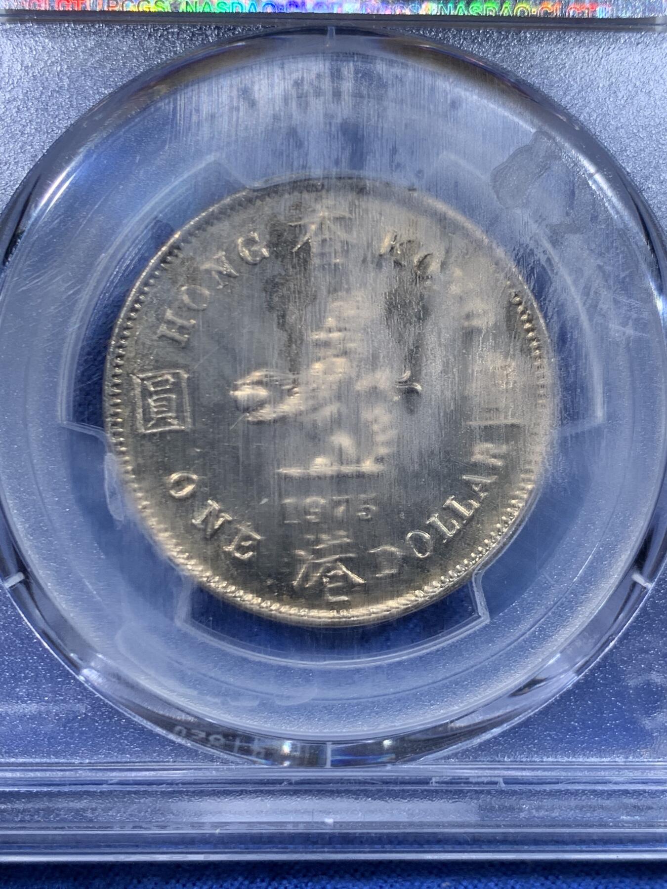 《竞宝斋》第447场 周日，周一，2场连拍 （全场包邮） PCGS MS64 中国香港1975年港币1元，大饼币，黄油光，分数好。盒子模糊了，细节见图。