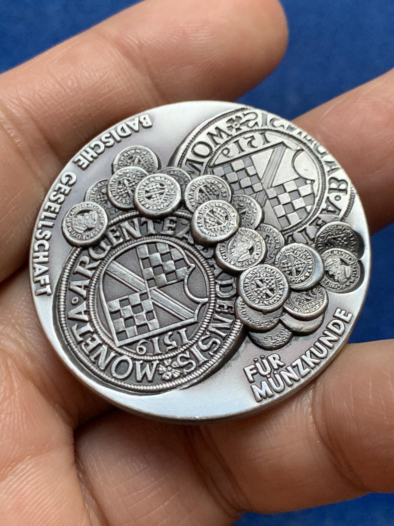 《竞宝斋》第447场 周日，周一，2场连拍 （全场包邮） 德国巴登地区货币历史纪念纯银银章 该章上环绕着多枚小型仿古钱币浮雕，这些是历史上巴登地区流通的货币样式，展示了该地区货币发展的多样性与历史脉络。35.3克，40.2mm，带边铭，双面高浮雕。