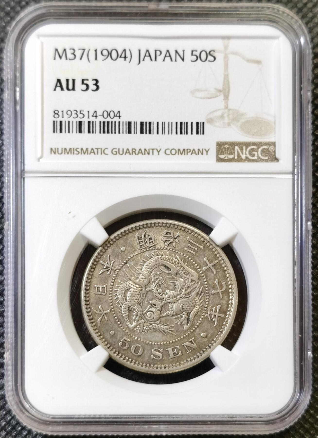 甄臻铺-世界币章拍卖（第44期）精品场拍品征集中，送拍享返佣金等优惠多多 NGC-AU53 日本 明治三十七年（1904年） 五十钱 龙洋银币 特年低评 原味包浆（13.48克/30.9mm/800银）