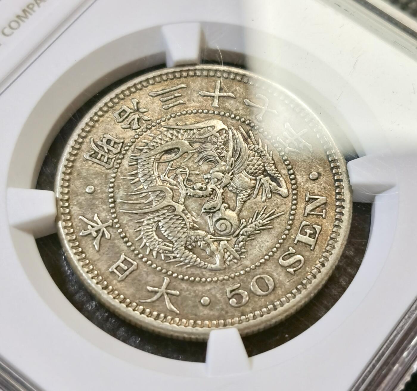 甄臻铺-世界币章拍卖（第44期）精品场拍品征集中，送拍享返佣金等优惠多多 NGC-AU53 日本 明治三十七年（1904年） 五十钱 龙洋银币 特年低评 原味包浆（13.48克/30.9mm/800银）