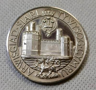 甄臻铺-世界币章拍卖（第44期）精品场拍品征集中，送拍享返佣金等优惠多多 1969年英国威尔士亲王查尔斯加冕纪念银章，直径38.6毫米，重26.6克，边缘有编号313。正面是查尔斯亲王侧像，JULY 1969字样，背面是卡那封城堡和威尔士龙，CAERNARFON字样，整体浮雕工艺精细，镜面底板，模具压制到位。这枚银章是英国皇室历史的重要见证，查尔斯亲王加冕仪式在卡那封城堡举行，意义重大。细节见图