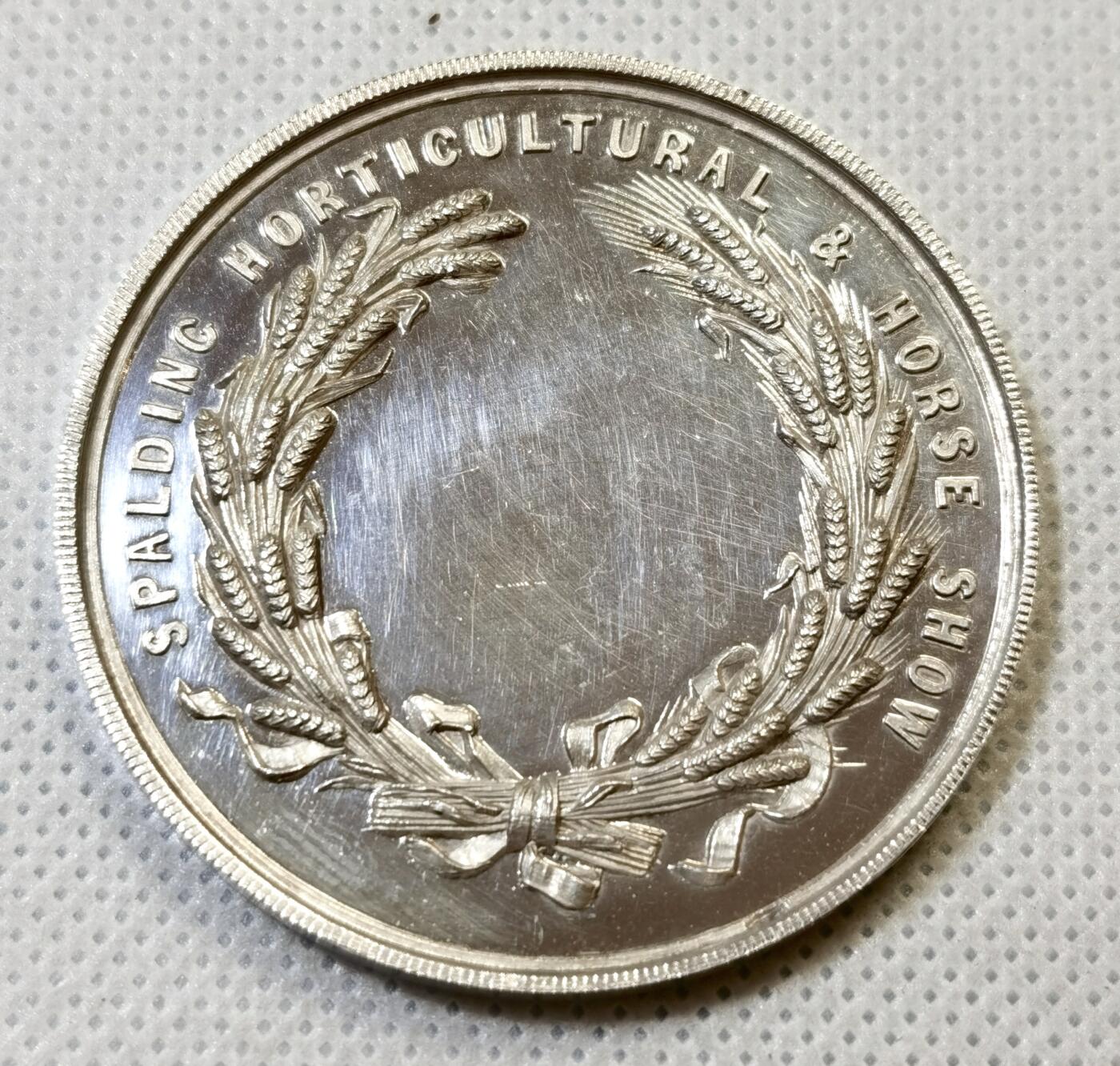 甄臻铺-世界币章拍卖（第44期）精品场拍品征集中，送拍享返佣金等优惠多多 19世纪英国Spalding农业与马术展览会纪念银章，直径47.3毫米，重37.4克，精美浮雕工艺。正面刻画农庄场景，两头牛和马匹，背景是传统英式建筑，周围环绕麦穗花环装饰。背面刻有