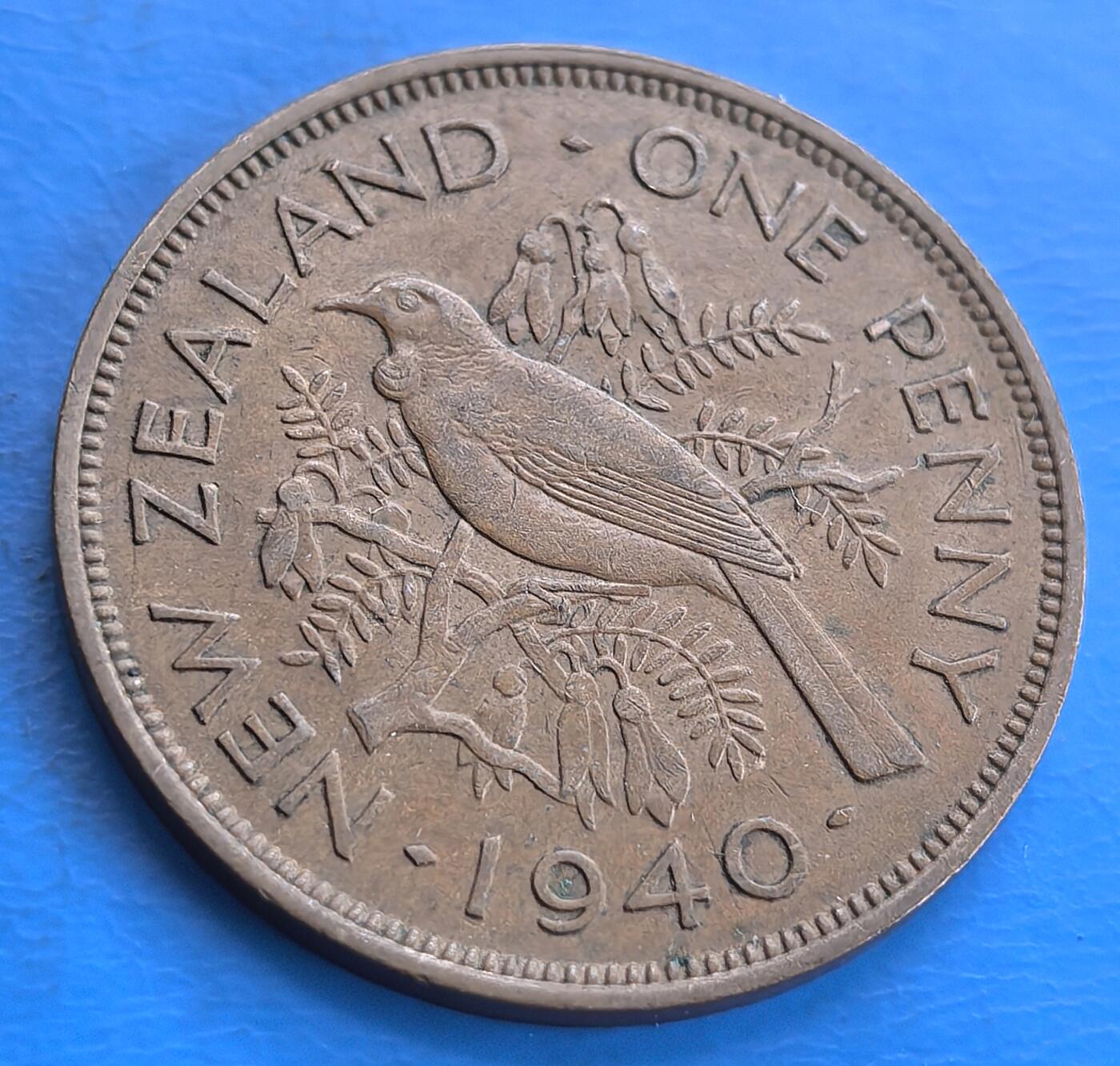 外国优质老铜币高银银币，周六九点倒数截拍，满百包邮，持续收拍 新西兰1940 年1便士。正面为乔治六世头像及 “GEORGE VI KING EMPEROR” ，体现英王室关联；背面是图伊鸟栖息于开满花的四翅槐树（毛利文化象征 ），环绕 “NEW ZEALAND ONE PENNY 1940” 。由伦纳德・康沃尔・米切尔设计，见证二战时新西兰货币与本土文化融合，具历史、收藏及文化研究价值 。