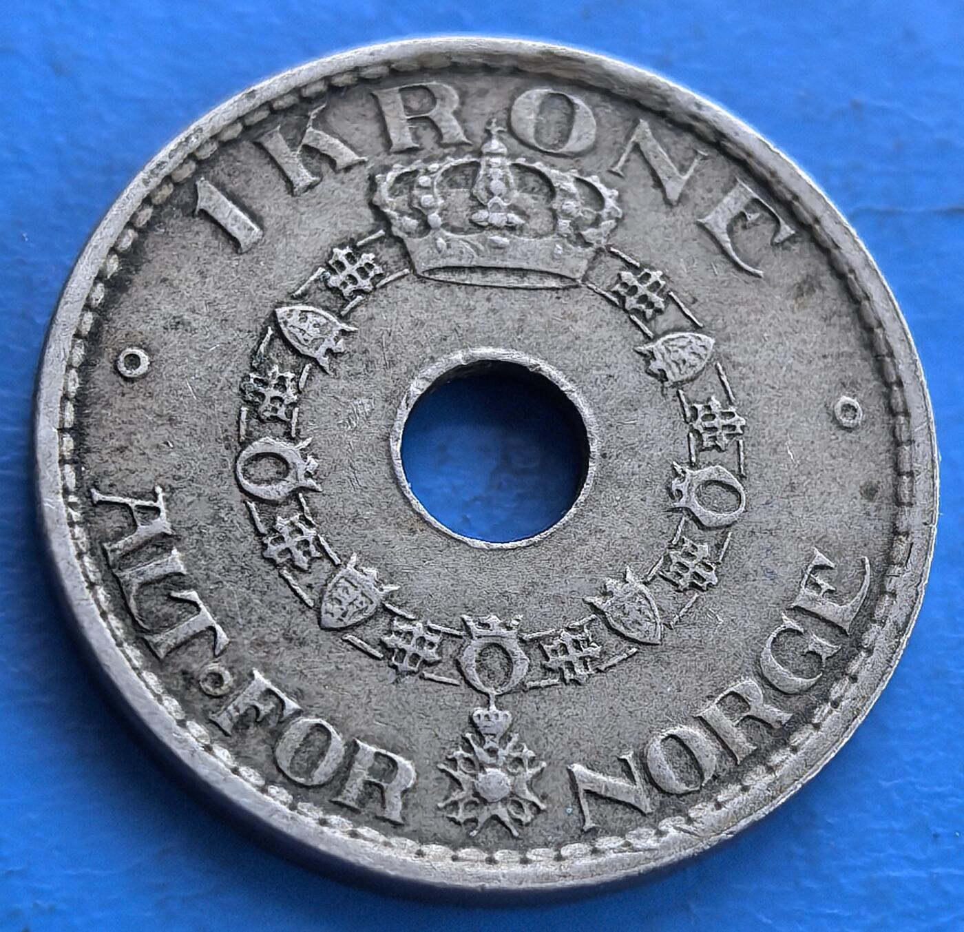 外国优质老铜币高银银币，周六九点倒数截拍，满百包邮，持续收拍 挪威 1925 年 1 克朗银币，正面由四个带皇冠的 “H7” 花押字组成十字，环绕 “HAAKON Ⅶ DEN SYVende NORGES KONGE（哈康七世，挪威第七任国王 ）” 及纪年 “1925”；背面圆孔外是皇家勋章链，搭配 “1 KRONE ALT FOR NORGE（1 克朗，一切为了挪威 ）” 铭文。圆孔设计独特，融合挪威王室象征与爱国 motto，见证哈康七世统治时期历史，对