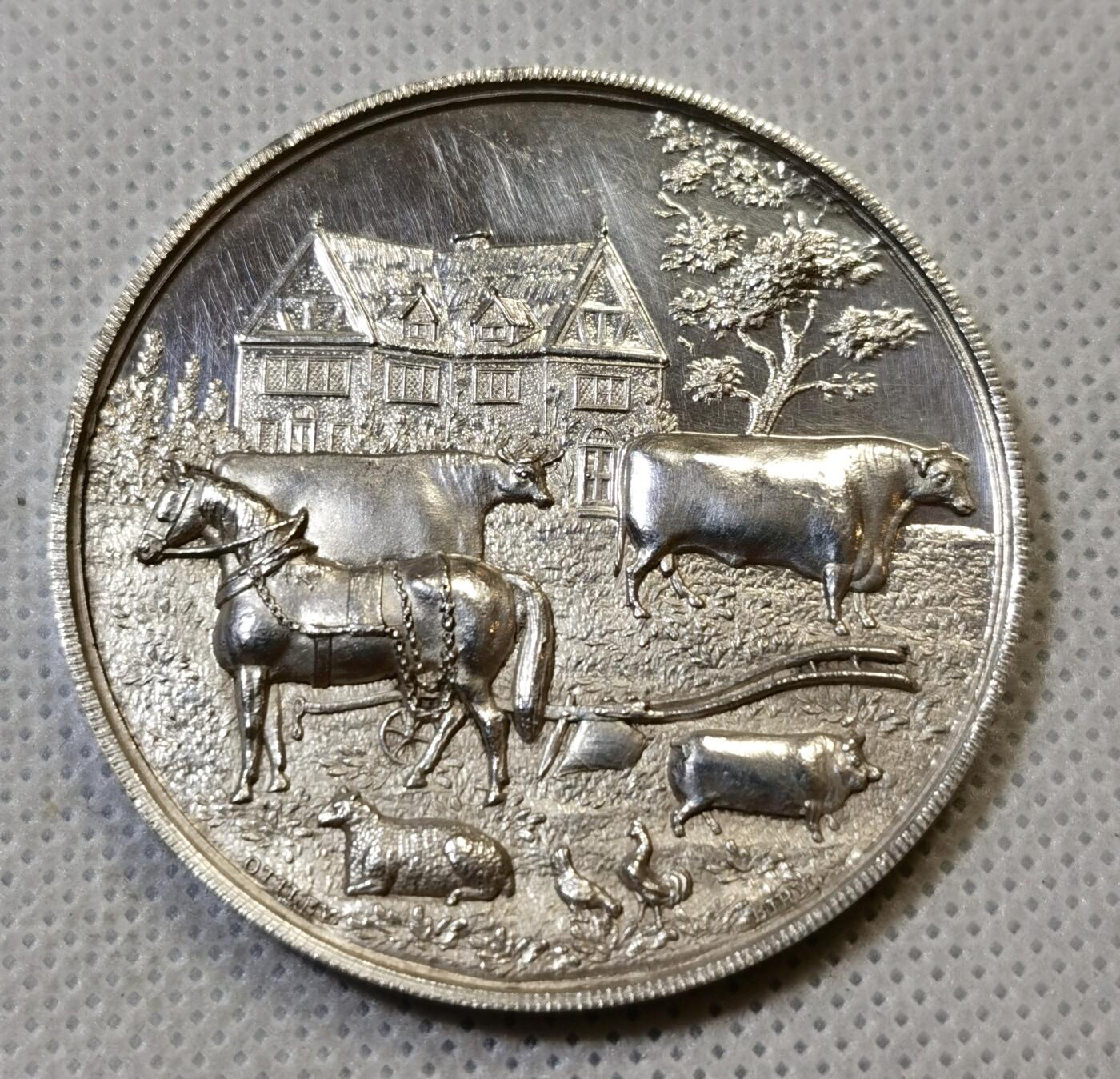 甄臻铺-世界币章拍卖（第44期）精品场拍品征集中，送拍享返佣金等优惠多多 19世纪英国Spalding农业与马术展览会纪念银章，直径47.3毫米，重37.4克，精美浮雕工艺。正面刻画农庄场景，两头牛和马匹，背景是传统英式建筑，周围环绕麦穗花环装饰。背面刻有