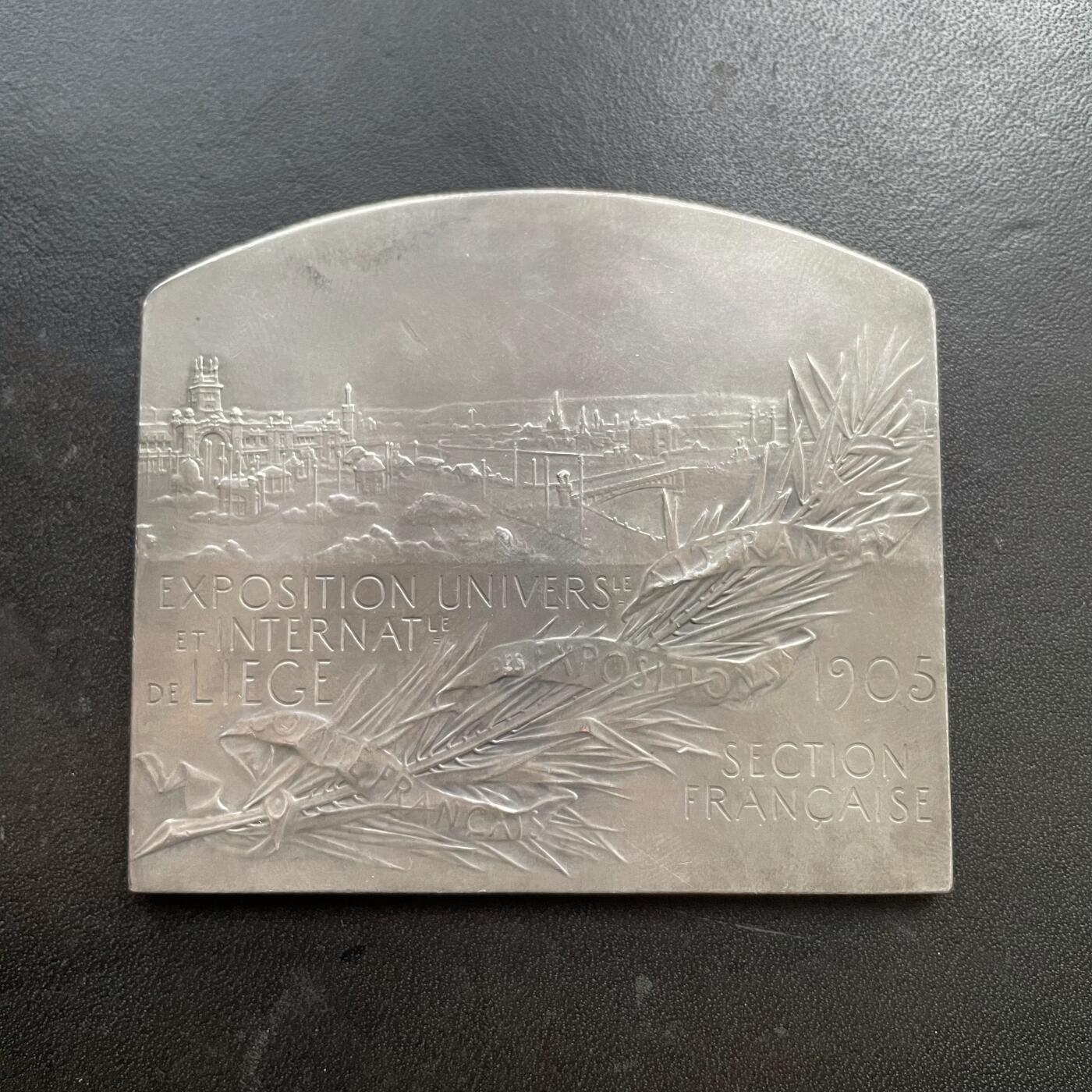 「木头集藏」“冬至雅藏”——章牌精品专场！ F. Vernon～法国银章 1905年比利时列日世博会，尺寸：63 x73mm，139 g，边铭：1 丰饶角 ARGENT。铜章较常见，银章非常罕见。正面是比利时女神在欢迎法国女神玛丽安娜，背面是世博会场馆。1905年世博会在比利时列日举办，以庆祝比利时王国独立70周年。此章由负责法国在境外参展事宜的“法国海外展览委员会”委托铸造。