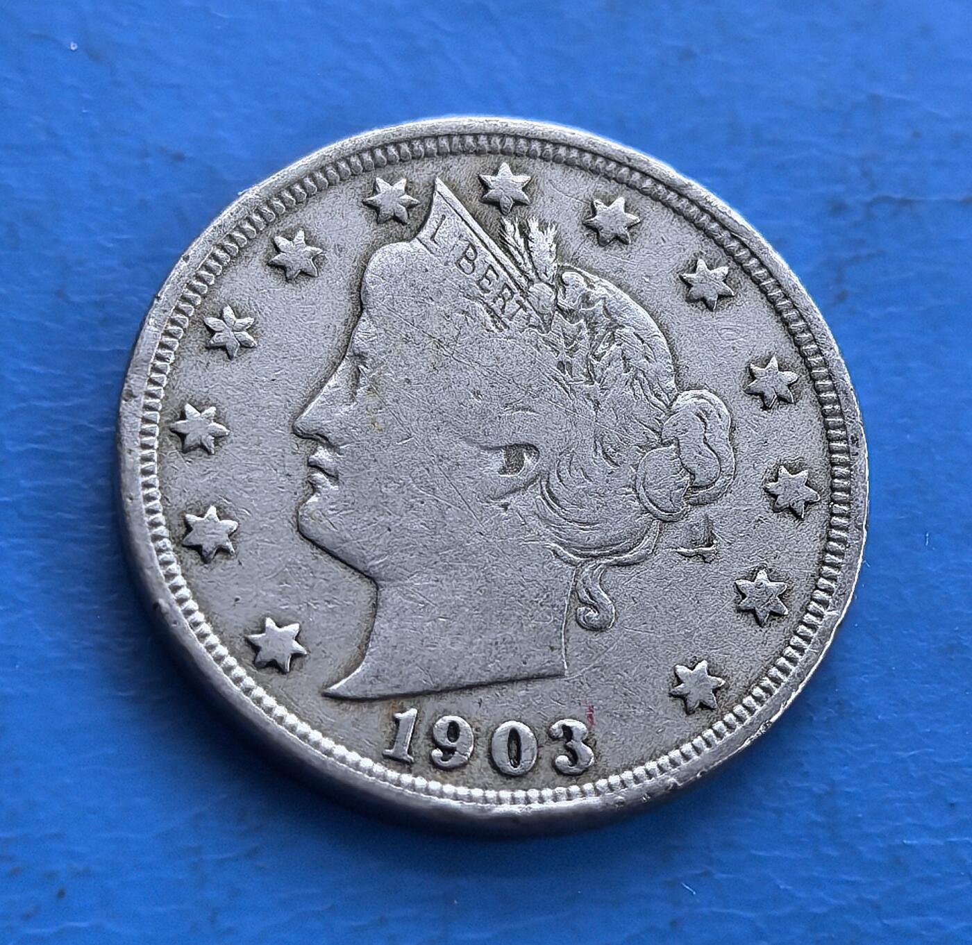 外国优质老铜币高银银币，周六九点倒数截拍，满百包邮，持续收拍 美国1903 年自由女神 5 分，正面是头戴 “LIBERTY” 冠饰的自由女神像，环饰星星，纪年 “1903”；背面铸 “UNITED STATES OF AMERICA 5 CENTS” ，搭配花环与 “V” 字（代表 5 分），体现美国货币文化。镍币材质、经典自由女神设计，对研究美国 19 世纪末 - 20 世纪初货币史、文化象征意义独特，是承载百年历史的实物