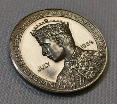 甄臻铺-世界币章拍卖（第44期）精品场拍品征集中，送拍享返佣金等优惠多多 1969年英国威尔士亲王查尔斯加冕纪念银章，直径38.6毫米，重26.6克，边缘有编号313。正面是查尔斯亲王侧像，JULY 1969字样，背面是卡那封城堡和威尔士龙，CAERNARFON字样，整体浮雕工艺精细，镜面底板，模具压制到位。这枚银章是英国皇室历史的重要见证，查尔斯亲王加冕仪式在卡那封城堡举行，意义重大。细节见图