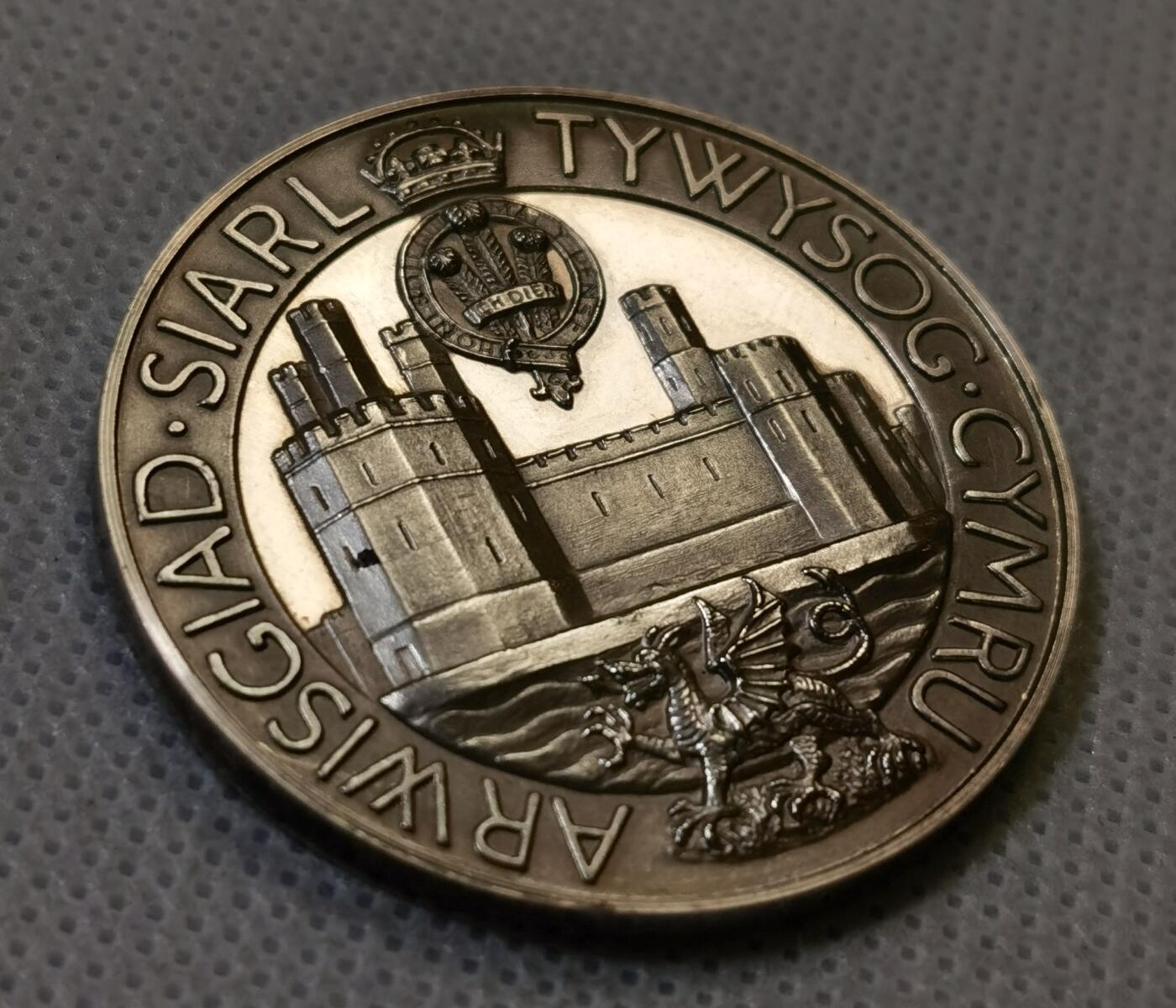 甄臻铺-世界币章拍卖（第44期）精品场拍品征集中，送拍享返佣金等优惠多多 1969年英国威尔士亲王查尔斯加冕纪念银章，直径38.6毫米，重26.6克，边缘有编号313。正面是查尔斯亲王侧像，JULY 1969字样，背面是卡那封城堡和威尔士龙，CAERNARFON字样，整体浮雕工艺精细，镜面底板，模具压制到位。这枚银章是英国皇室历史的重要见证，查尔斯亲王加冕仪式在卡那封城堡举行，意义重大。细节见图