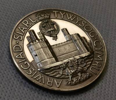 甄臻铺-世界币章拍卖（第44期）精品场拍品征集中，送拍享返佣金等优惠多多 1969年英国威尔士亲王查尔斯加冕纪念银章，直径38.6毫米，重26.6克，边缘有编号313。正面是查尔斯亲王侧像，JULY 1969字样，背面是卡那封城堡和威尔士龙，CAERNARFON字样，整体浮雕工艺精细，镜面底板，模具压制到位。这枚银章是英国皇室历史的重要见证，查尔斯亲王加冕仪式在卡那封城堡举行，意义重大。细节见图