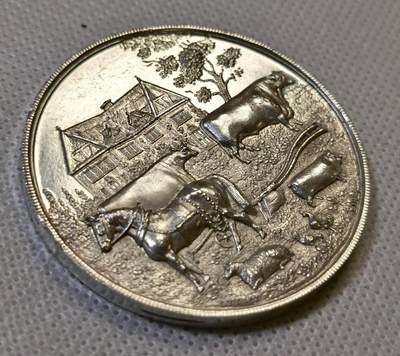 甄臻铺-世界币章拍卖（第44期）精品场拍品征集中，送拍享返佣金等优惠多多 19世纪英国Spalding农业与马术展览会纪念银章，直径47.3毫米，重37.4克，精美浮雕工艺。正面刻画农庄场景，两头牛和马匹，背景是传统英式建筑，周围环绕麦穗花环装饰。背面刻有
