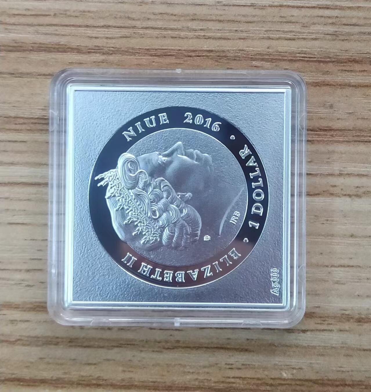 第185期拍卖  纽埃2016年，罗马诺 名画系列-“耶稣和抹大拉的玛利亚”，异形、彩色精制银币. 盒证全. 带展示支架的原盒，高颜值漂亮银币. 大师名画系列银币. 国外售价151美元